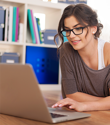 Jeune femme utilisant un ordinateur portable pour gérer ses services de télécommunication avec Vision Link.